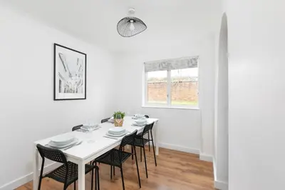 a white dining room with a white table and chairs at Skyvillion - STEVENAGE SPACIOUS & COZY 3Bed House with Parking, Wifi, Garden in Aston End