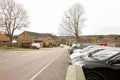 a row of parked cars in a parking lot at Skyvillion - STEVENAGE SPACIOUS & COZY 3Bed House with Parking, Wifi, Garden in Aston End