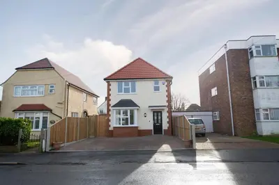 a house with a fence and two buildings at La Casita - Inside the Gates of Frinton-On-Sea in Frinton-on-Sea