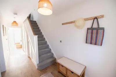 a staircase in a home with white walls and wooden floors at La Casita - Inside the Gates of Frinton-On-Sea in Frinton-on-Sea
