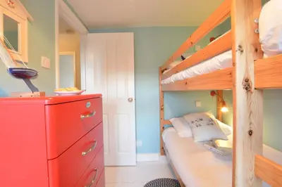 a bedroom with a bunk bed and a red dresser at 6 Coastguard Cottages, Aldeburgh in Aldeburgh