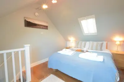 a bedroom with a blue bed with two towels on it at 6 Coastguard Cottages, Aldeburgh in Aldeburgh