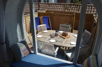 a wooden table and chairs on a patio at 6 Coastguard Cottages, Aldeburgh in Aldeburgh