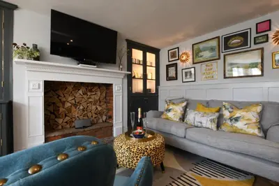 a living room with a couch and a fireplace at Cragside, Aldeburgh in Aldeburgh