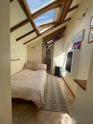 a bedroom with a bed and a television in it at Cobwebs in Kedington