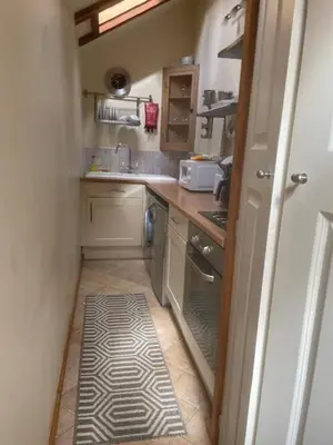 a small kitchen with a sink and a stove at Cobwebs in Kedington