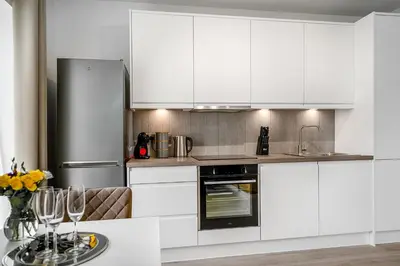 a kitchen with white cabinets and a table with wine glasses at Citystay Living - Finch House in Cambridge