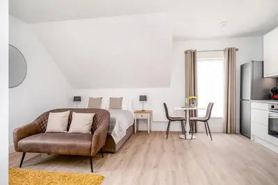a bedroom with a bed and a chair and a table at Citystay Living - Finch House in Cambridge