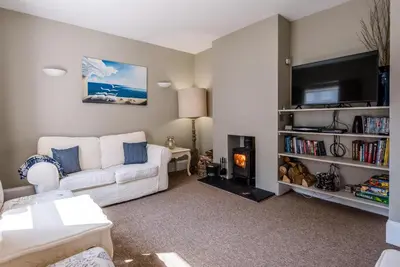 a living room with a white couch and a tv at Cornerstone, Aldeburgh in Aldeburgh