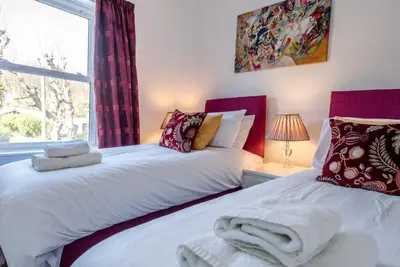 two beds in a bedroom with a window at Cornerstone, Aldeburgh in Aldeburgh