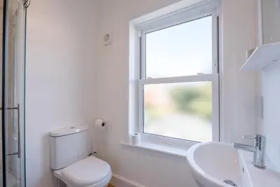 a bathroom with a toilet and a sink and a window at Cornerstone, Aldeburgh in Aldeburgh