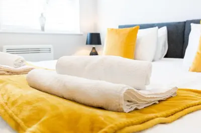 a pile of towels sitting on top of a bed at Velvet 2-bedroom apartment, Brewery Road, Hoddesdon in Hoddesdon