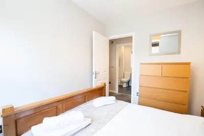 a bedroom with a bed with two towels on it at Velvet 2-bedroom apartment, Brewery Road, Hoddesdon in Hoddesdon