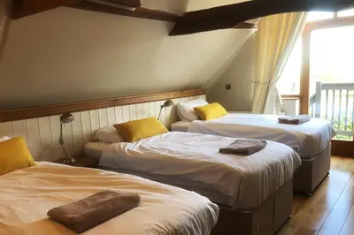 a room with two beds with towels on them at The Coach House Barn - Valley Farm in Sudbourne