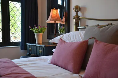 a bedroom with a bed with two pillows and a lamp at Badminton, Thorpeness in Thorpeness