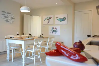 a kitchen and dining room with a table and chairs at Somewhere Only We Know, Aldeburgh in Aldeburgh