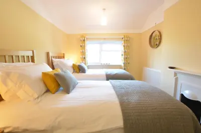 a bedroom with two beds and a window at Somewhere Only We Know, Aldeburgh in Aldeburgh