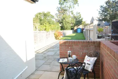 a small patio with two chairs and a table at Somewhere Only We Know, Aldeburgh in Aldeburgh