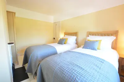 two beds in a hotel room next to each other at Somewhere Only We Know, Aldeburgh in Aldeburgh