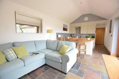 a living room with a couch and a kitchen at The Knox - Beautiful Two Bed Cottage Near Orford in Woodbridge