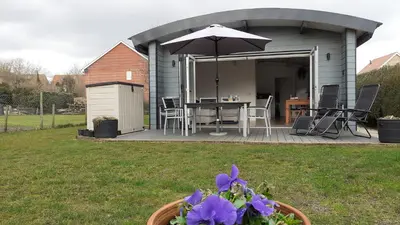 a patio with an umbrella and a table with purple flowers at The Annexe, Cornfields in Elmswell