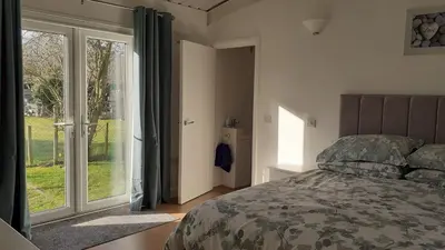 a bedroom with a bed and a sliding glass door at The Annexe, Cornfields in Elmswell