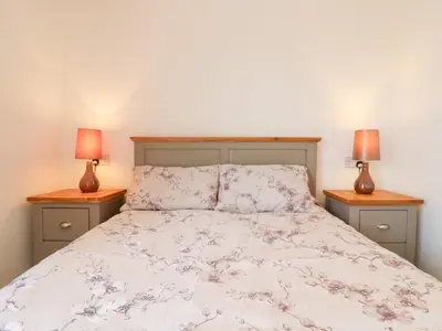 a bedroom with a bed with two lamps on two tables at Ninety Eight in Southend-on-Sea