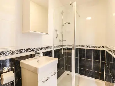 a white bathroom with a sink and a shower at 493 Little Wakering Road in Southend-on-Sea