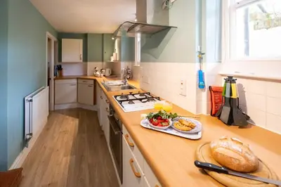 a kitchen with a counter with a plate of food on it at 4 Crespigny House - Aldeburgh Coastal Cottages in Aldeburgh