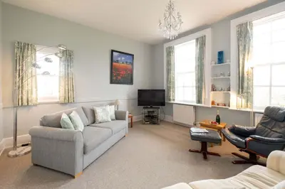 a living room with a couch and a tv at 4 Crespigny House - Aldeburgh Coastal Cottages in Aldeburgh
