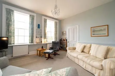 a living room with a couch and a chair at 4 Crespigny House - Aldeburgh Coastal Cottages in Aldeburgh