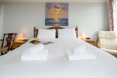a bedroom with a white bed with two white pillows at 4 Crespigny House - Aldeburgh Coastal Cottages in Aldeburgh