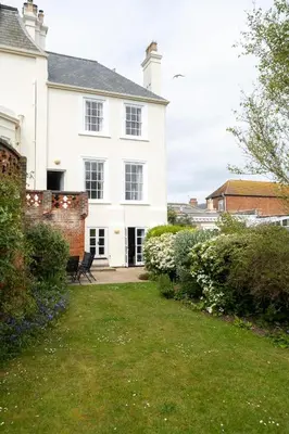 a white house with a lawn in front of it at 4 Crespigny House - Aldeburgh Coastal Cottages in Aldeburgh