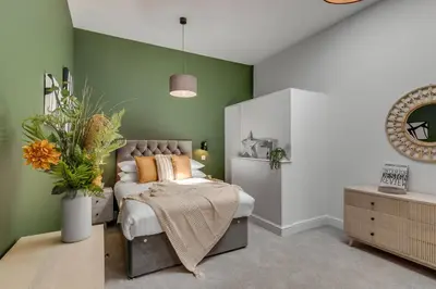 a bedroom with a bed and a green wall at 4 Bedroom House in Larling, near Thetford in Snetterton
