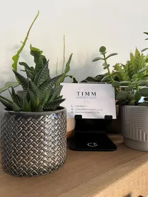 two potted plants sitting on a shelf with a sign at 4 Bedroom House in Larling, near Thetford in Snetterton