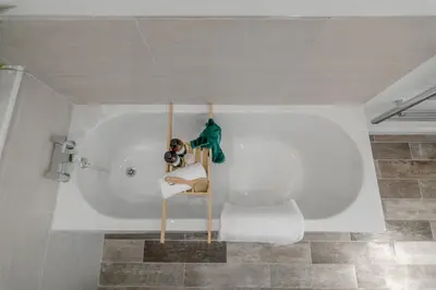 a white bath tub with a person sitting in it at 4 Bedroom House in Larling, near Thetford in Snetterton
