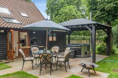a patio with a table and chairs and an umbrella at 3 Bed in Ketteringham oc-1878 in East Carleton