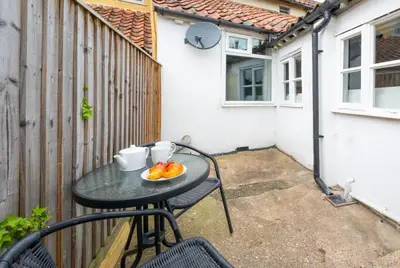 a table with a plate of fruit on a patio at 2 Bed in Halesworth oc-7lr in Halesworth
