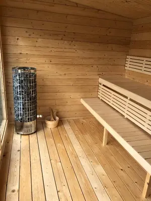 a sauna with a bench and a heater in it at The Tawny Shepherd Hut, Whitehouse Farm in Stowmarket