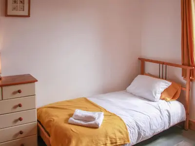 a small bedroom with a bed and a dresser at Haycart Barn in Norwich
