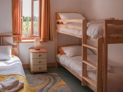 a bedroom with two bunk beds and a window at Haycart Barn in Norwich