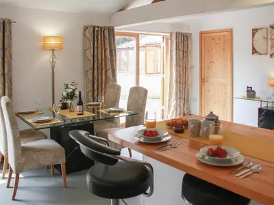 a dining room with a table and chairs at Haycart Barn in Norwich