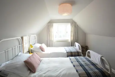 a room with three beds and a window at 2 The Dunes, Thorpeness in Thorpeness