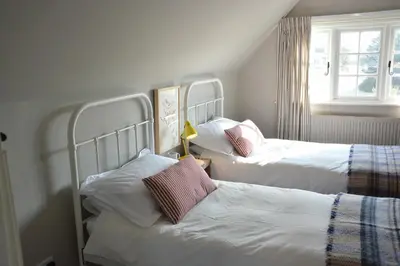 a bedroom with two beds and a window at 2 The Dunes, Thorpeness in Thorpeness