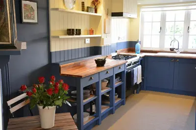 a kitchen with a blue island with a counter top at 2 The Dunes, Thorpeness in Thorpeness