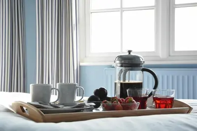 a tray of food and drinks on a bed at 2 The Dunes, Thorpeness in Thorpeness
