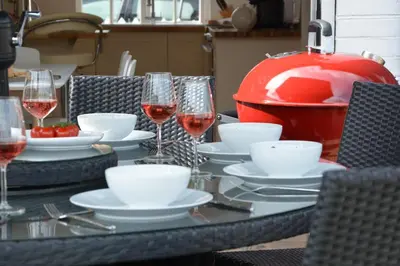 a table with glasses of wine and plates of food at 4 The Dunes, Thorpeness in Thorpeness