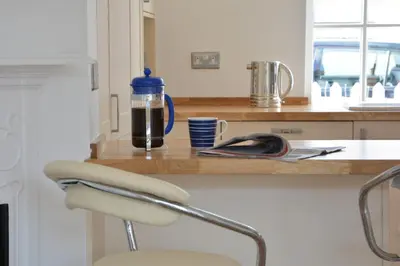 a kitchen counter with a bottle of water and a chair at 4 The Dunes, Thorpeness in Thorpeness