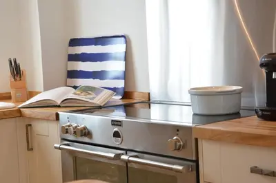 a kitchen with a stove and a book on the counter at 4 The Dunes, Thorpeness in Thorpeness