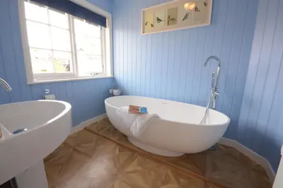 a bathroom with a white tub and a sink at 4 The Dunes, Thorpeness in Thorpeness